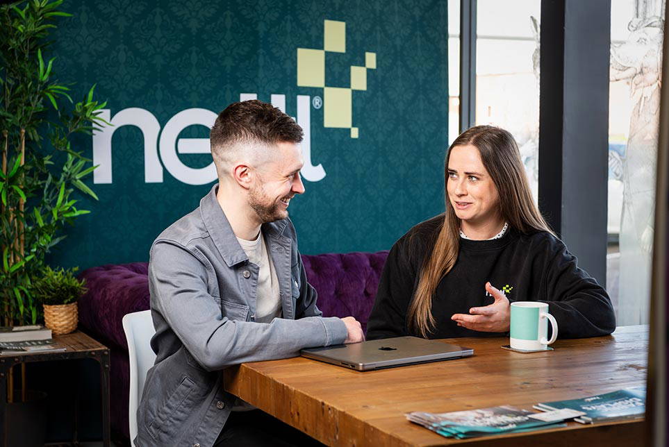 Two people in a Nettl store discussing graphic design projects.