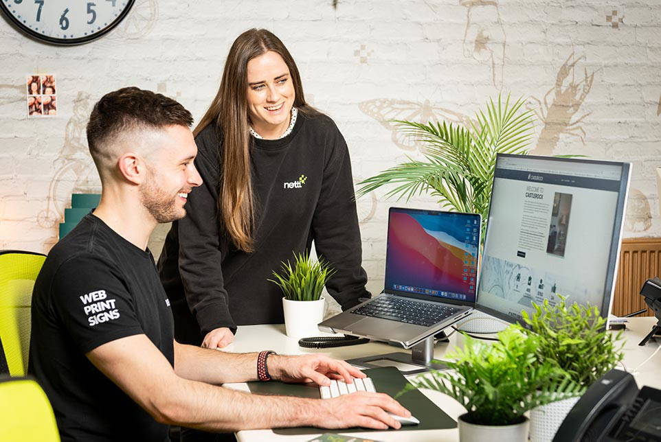 Two Nettl employees working on a digital project together.