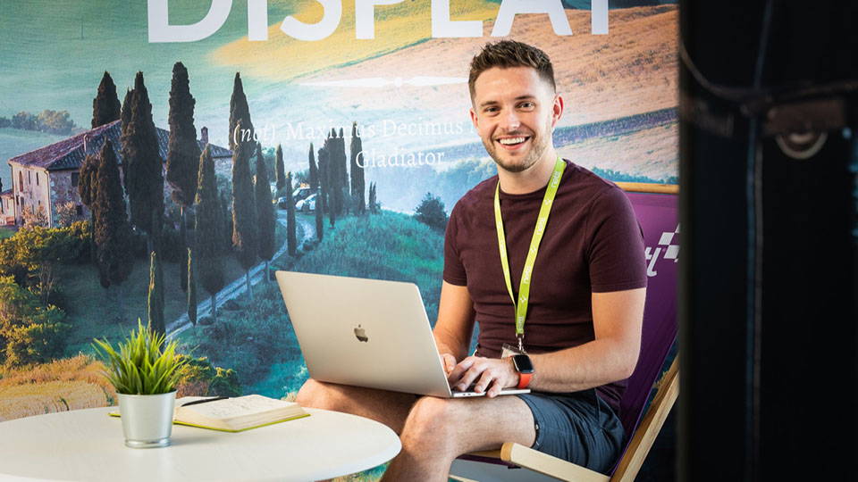 An image of a Nettl specialist working on a laptop in a lounge area