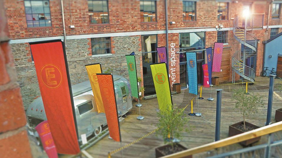 An image of multiple flags with branding in a lot.