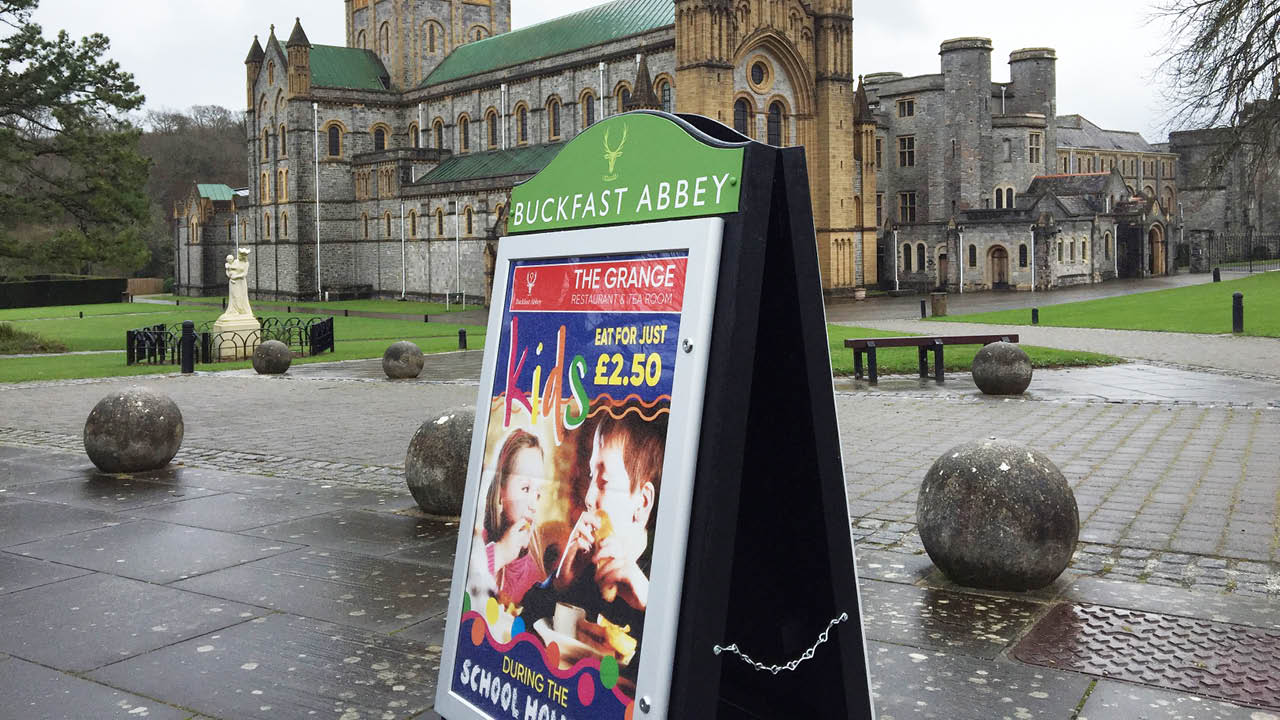 A pavement sign placed in front of a cathedral