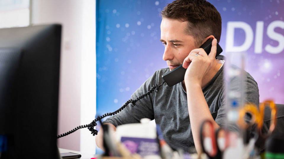 A Nettl employee answering the phone for a potential client.