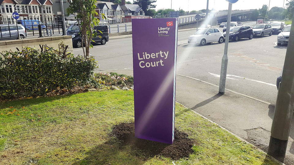 A totem sign posted outside of a parking lot.